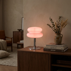 Mid-century glass table lamp with light yellow glass shade glowing in a cozy living room