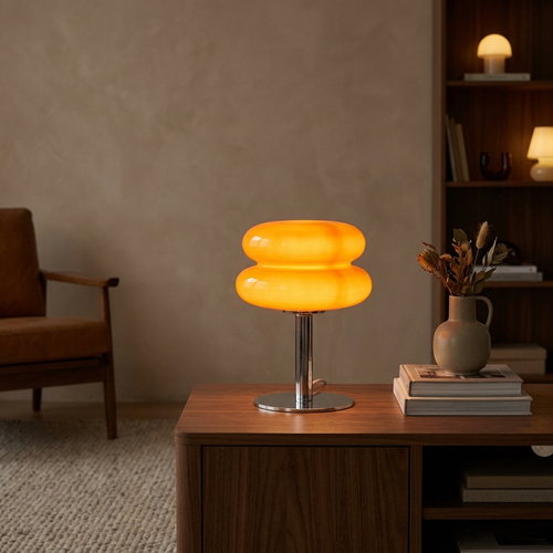 Mid-century glass table lamp with orange glass shade glowing in a cozy living room
