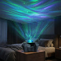 Aurora star projector on a nightstand casting green, blue and violet aurora and laser stars across a dark bedroom