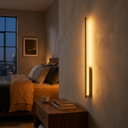 AuraLineo wall lamp glowing warm beside a bed in a cozy modern bedroom