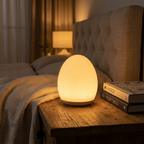 Egg silicone night lamp glowing warm amber on a cozy bedside nightstand at night