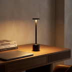 Aluminum touch desk lamp glowing warm on a clean modern home-office desk at night