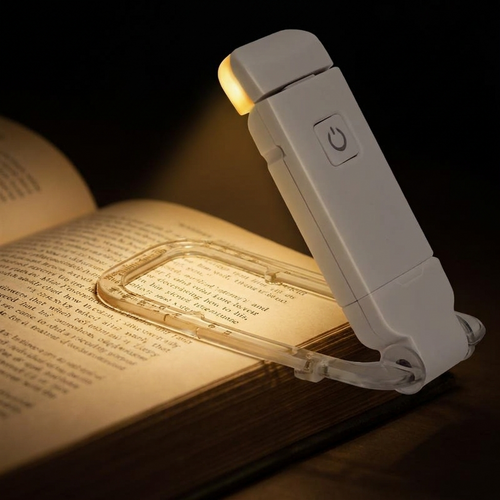 AuraLights clip-on book light with warm amber glow on an open book at night