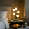 French bell orchid table lamp glowing warm on a nightstand in an elegant bedroom